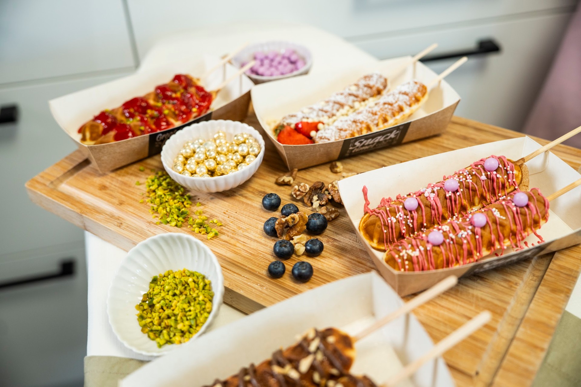 Handdekorierte Waffeln am Stiel mit Erdbeeren und rosa Schokolade